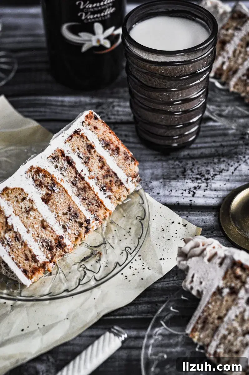 Baileys Irish Cream Cake with Gluten-Free Option 4 A slice of baileys & coffee flavored cake sitting on a plate. It has six golden layers with frosting between each layer.