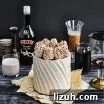 A light tan bailey's and coffee flavored cake topped with large buttercream swirls.