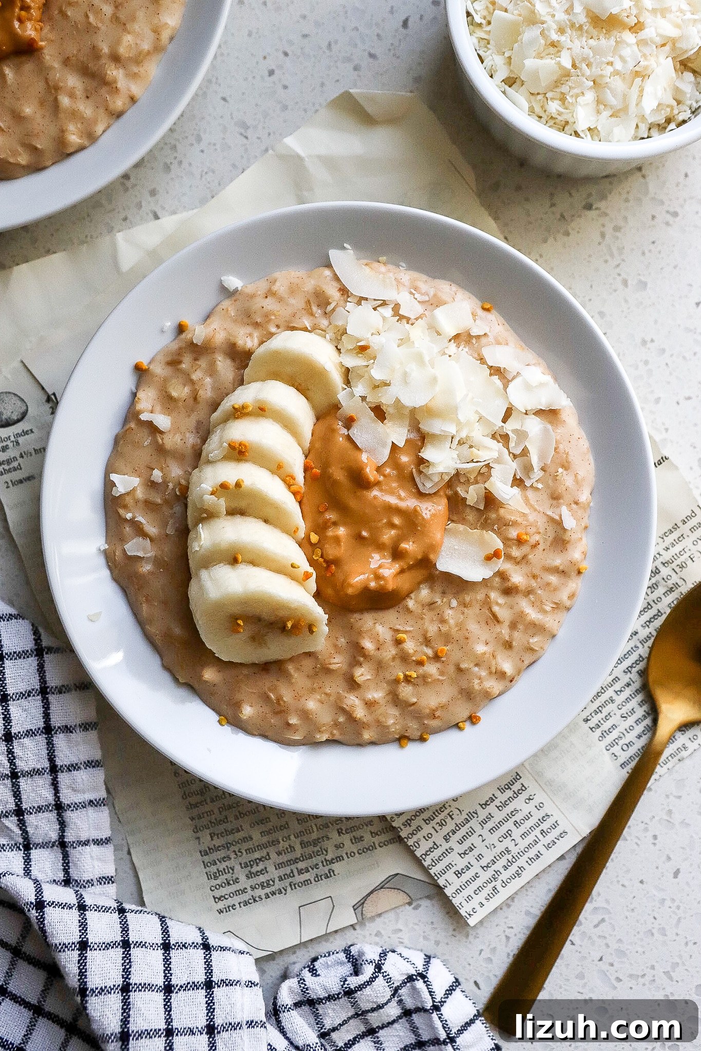 top down view of oatmeal breakfast with banana peanut butter and coconut flakes