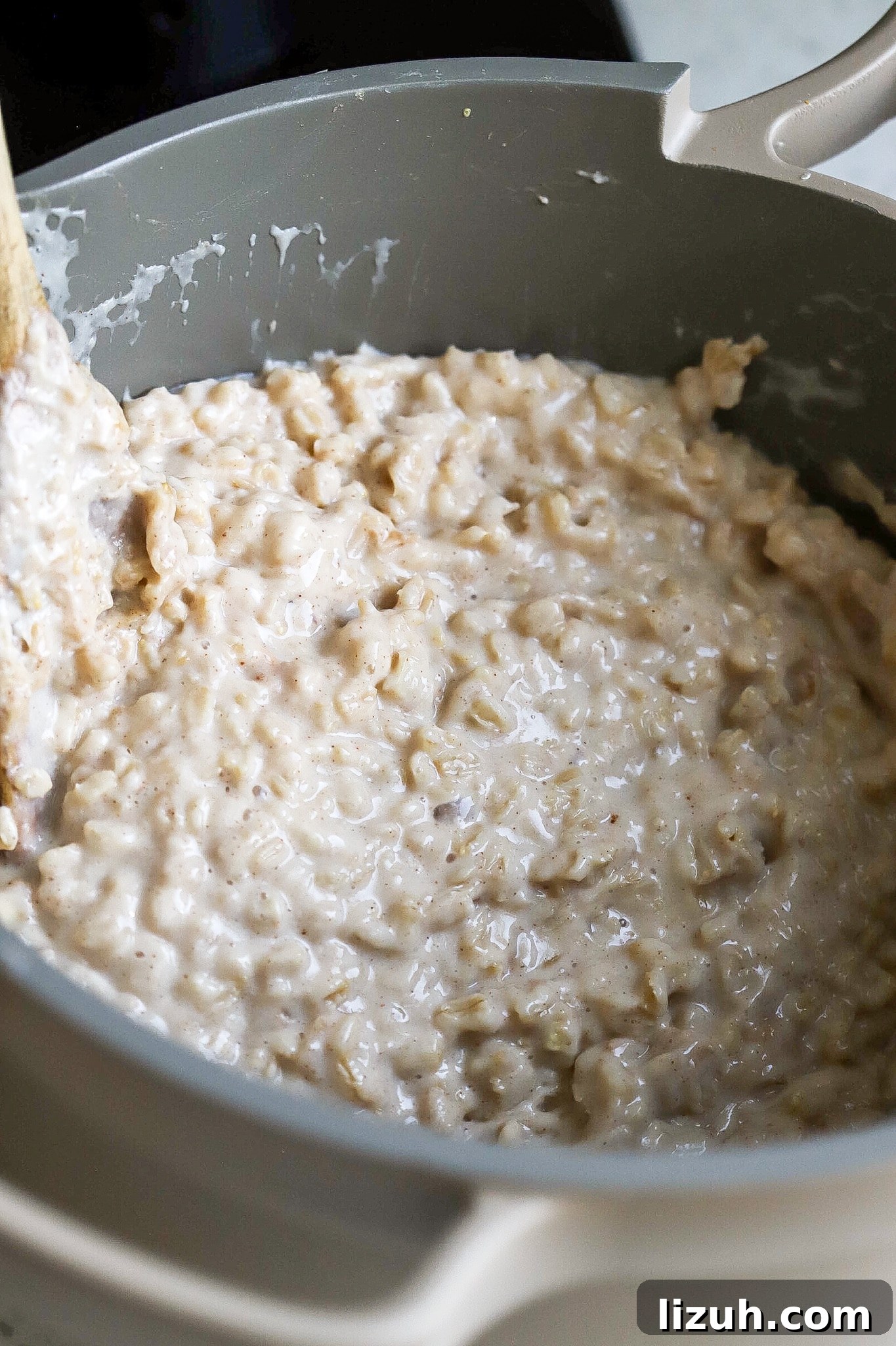 shot of creamy porridge in grey saucepan