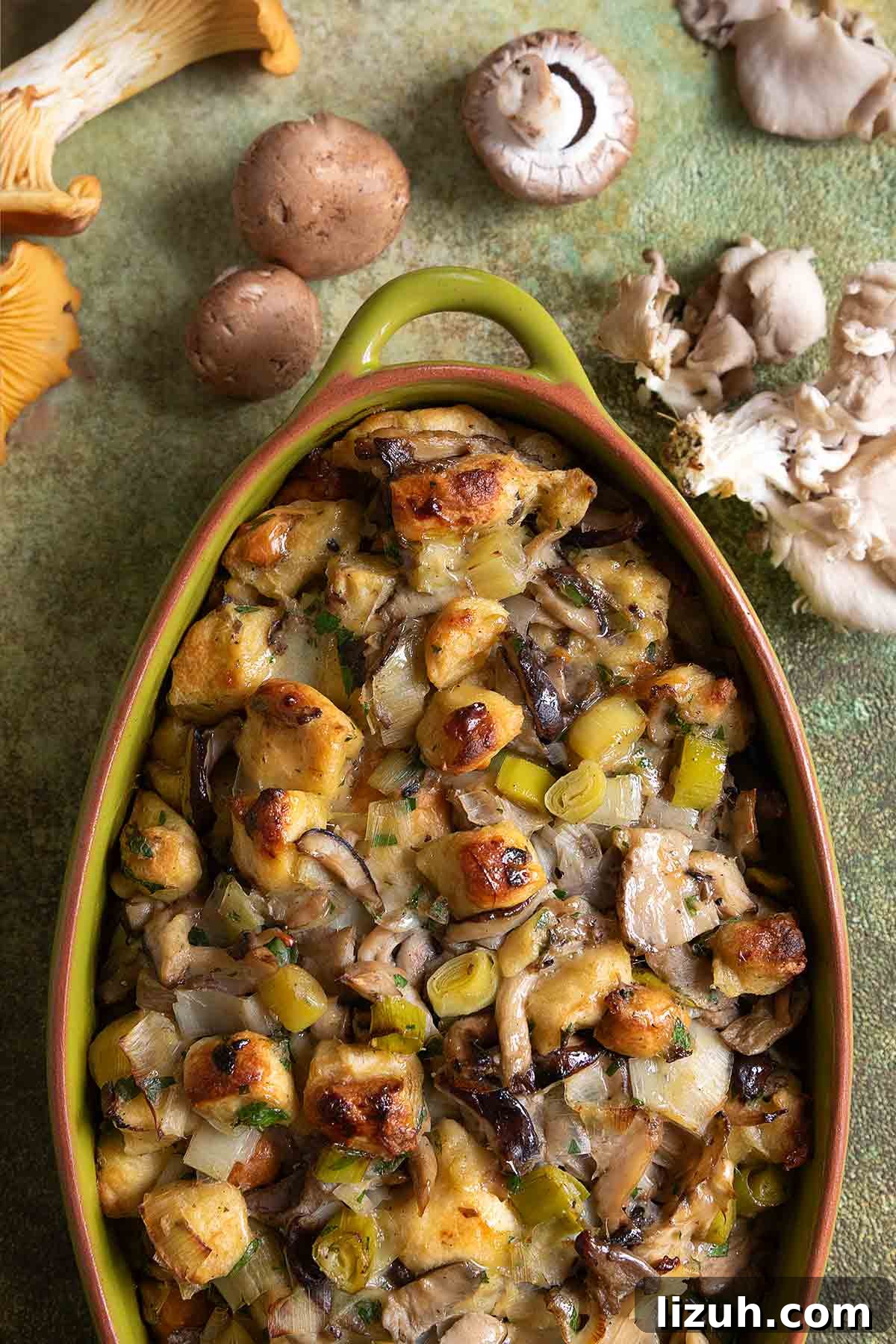 An oval casserole dish filled with wild mushroom stuffing.