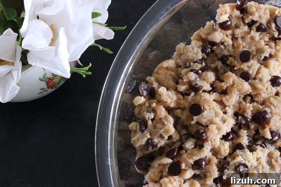 Chocolate chip cookie batter in a clear glass bowl