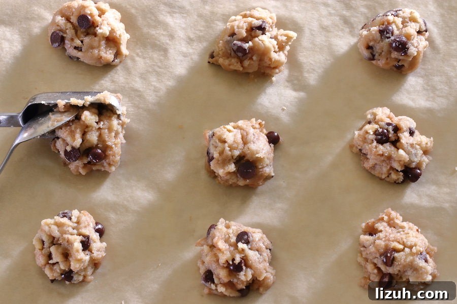 Parchment lined cookie sheet with chocolate chip cookies ready for the oven