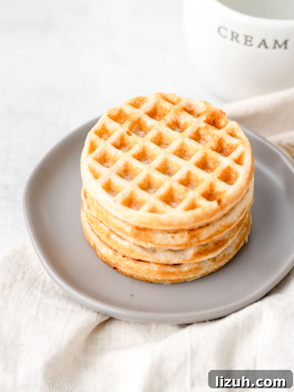 Gluten free waffles stacked on a plate.
