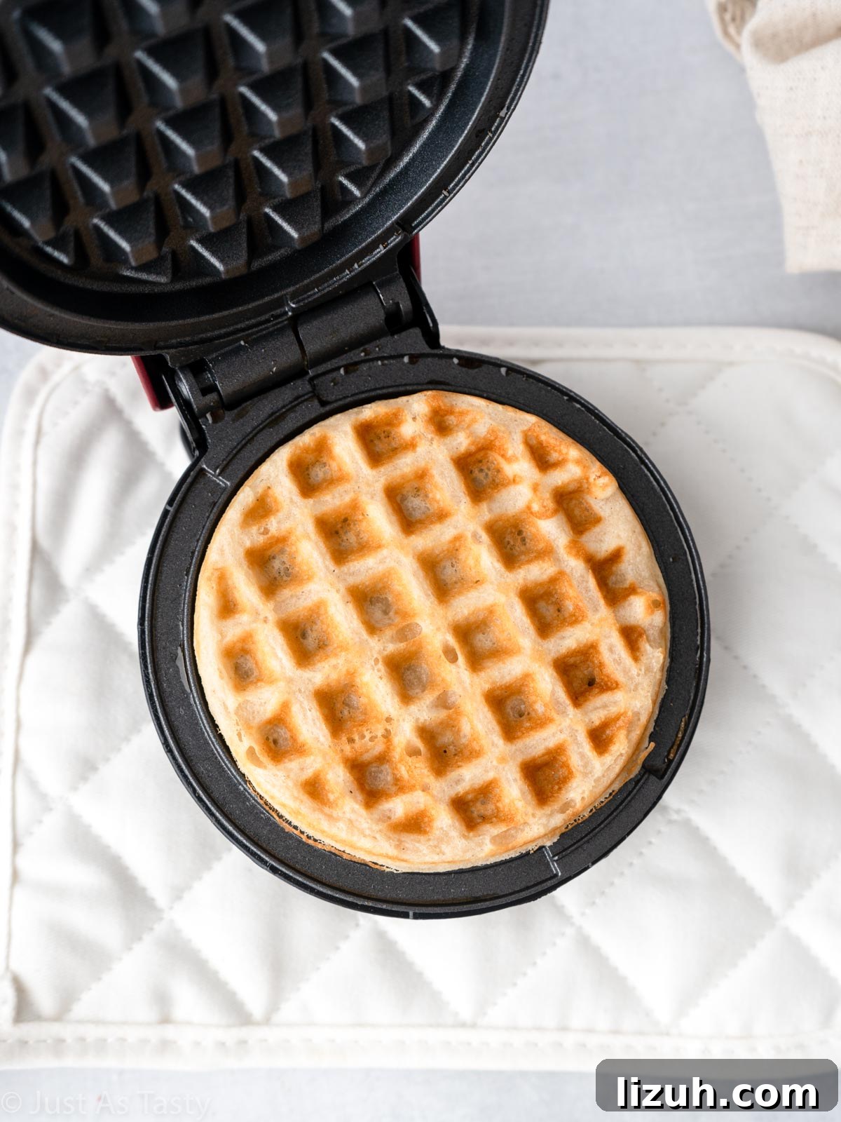 Cooked waffle in a waffle iron.