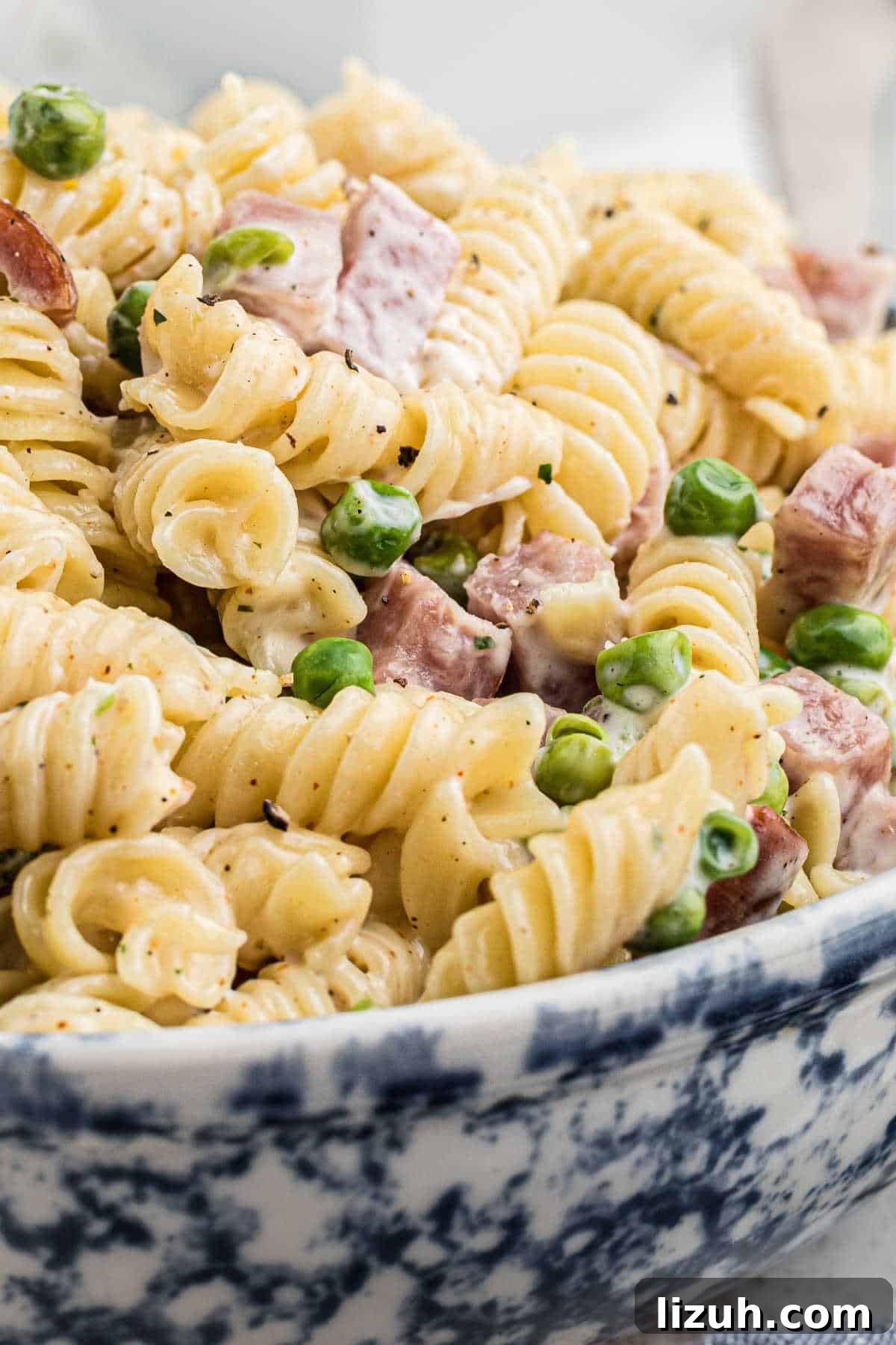 Ruby Tuesday-Style Ham and Pea Pasta Salad Recipe 2 Very close up side shot of a bowl of Ruby Tuesday ham and pea pasta salad.