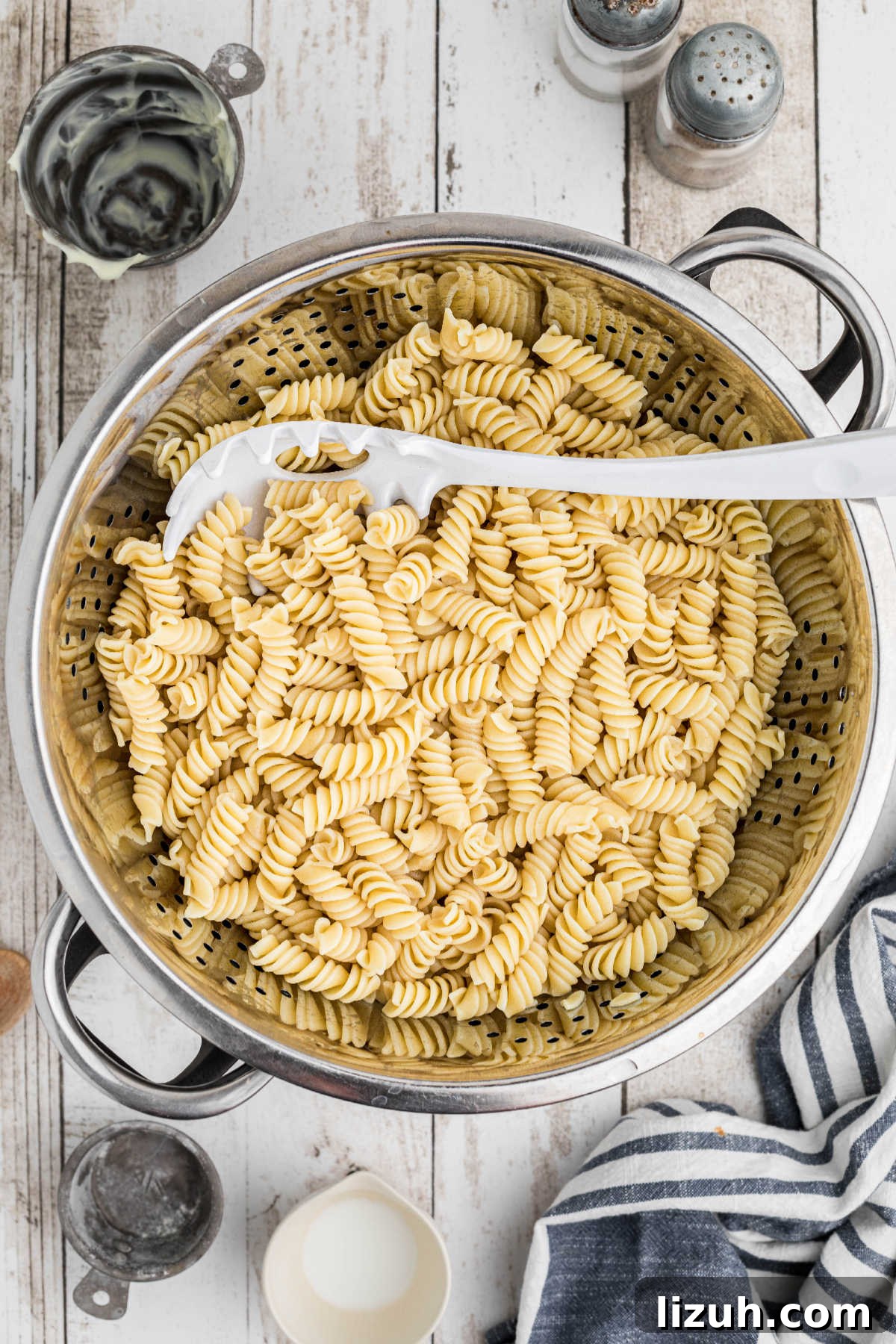 Ruby Tuesday-Style Ham and Pea Pasta Salad Recipe 4 Cooked pasta in a colander, with a pasta fork.