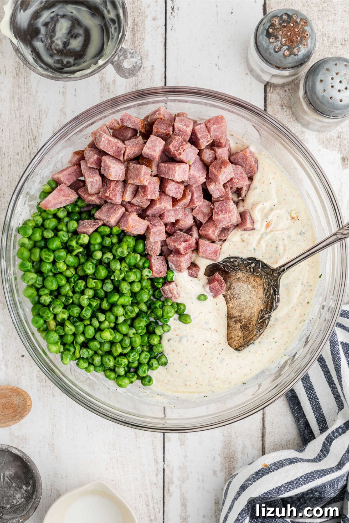 Ruby Tuesday-Style Ham and Pea Pasta Salad Recipe 6 A large mixing bowl with chopped ham, peas and dressing about to be mixed together.