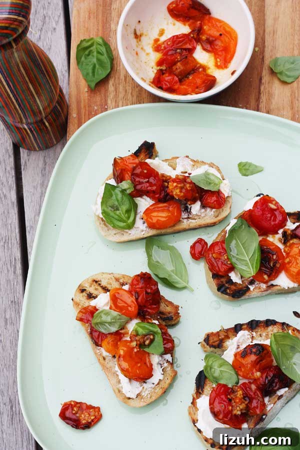 Slow-Roasted Tomato and Ricotta Bruschetta Recipe 3 Overhead of a white plate with tomato and ricotta bruschetta on it.