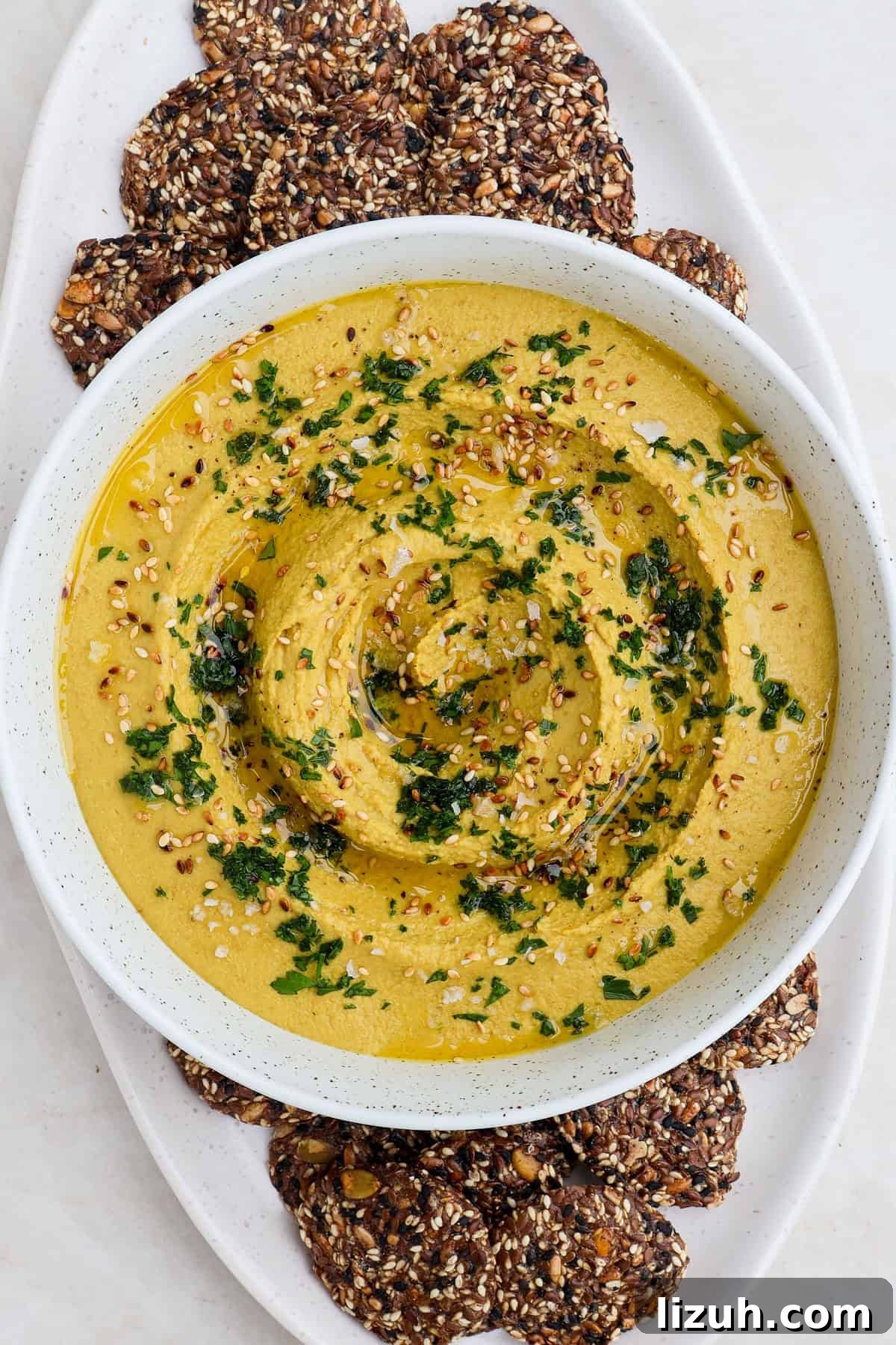 Hummus in a bowl on a cracker platter.