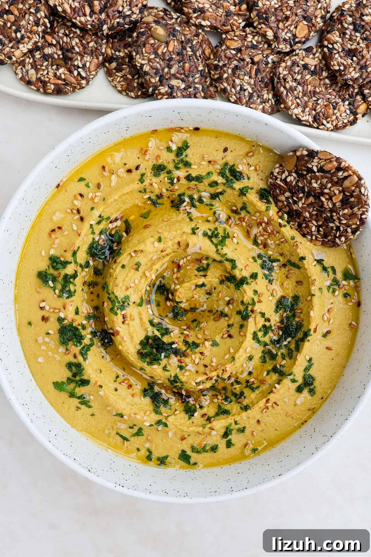 Hummus with a cracker dipped in on the side.