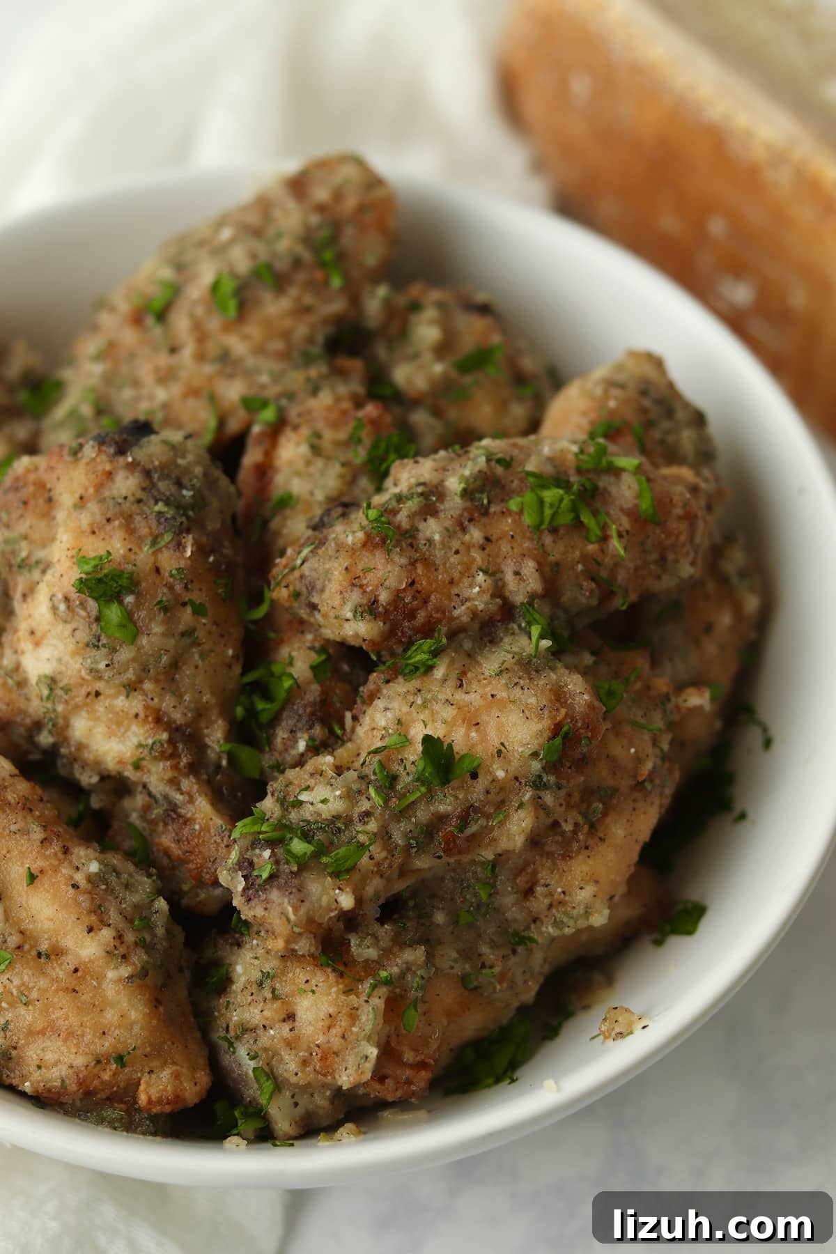 Crispy Garlic Parmesan Air Fryer Chicken Wings 2 Air Fryer Garlic Parmesan Wings in a bowl.