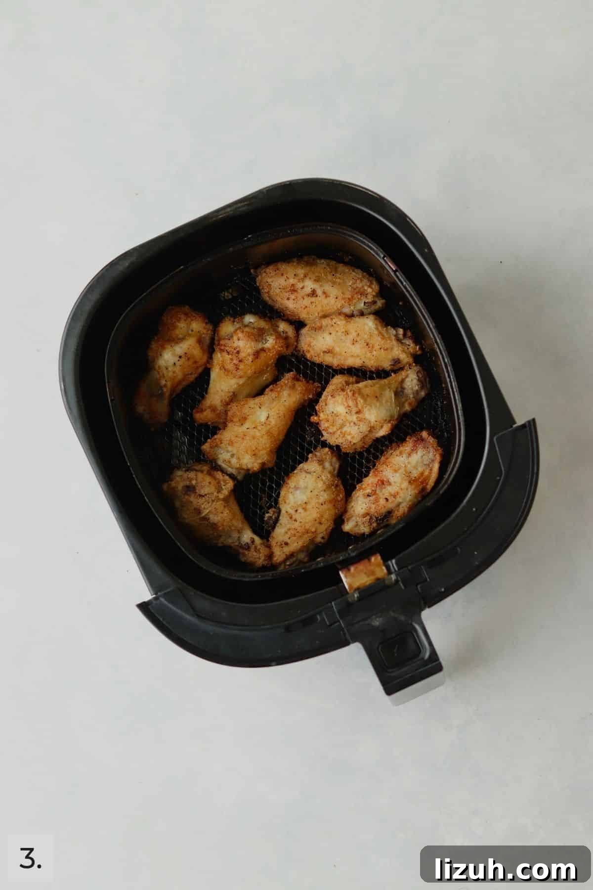 Crispy Garlic Parmesan Air Fryer Chicken Wings 6 Cooked chicken wings in air fryer.