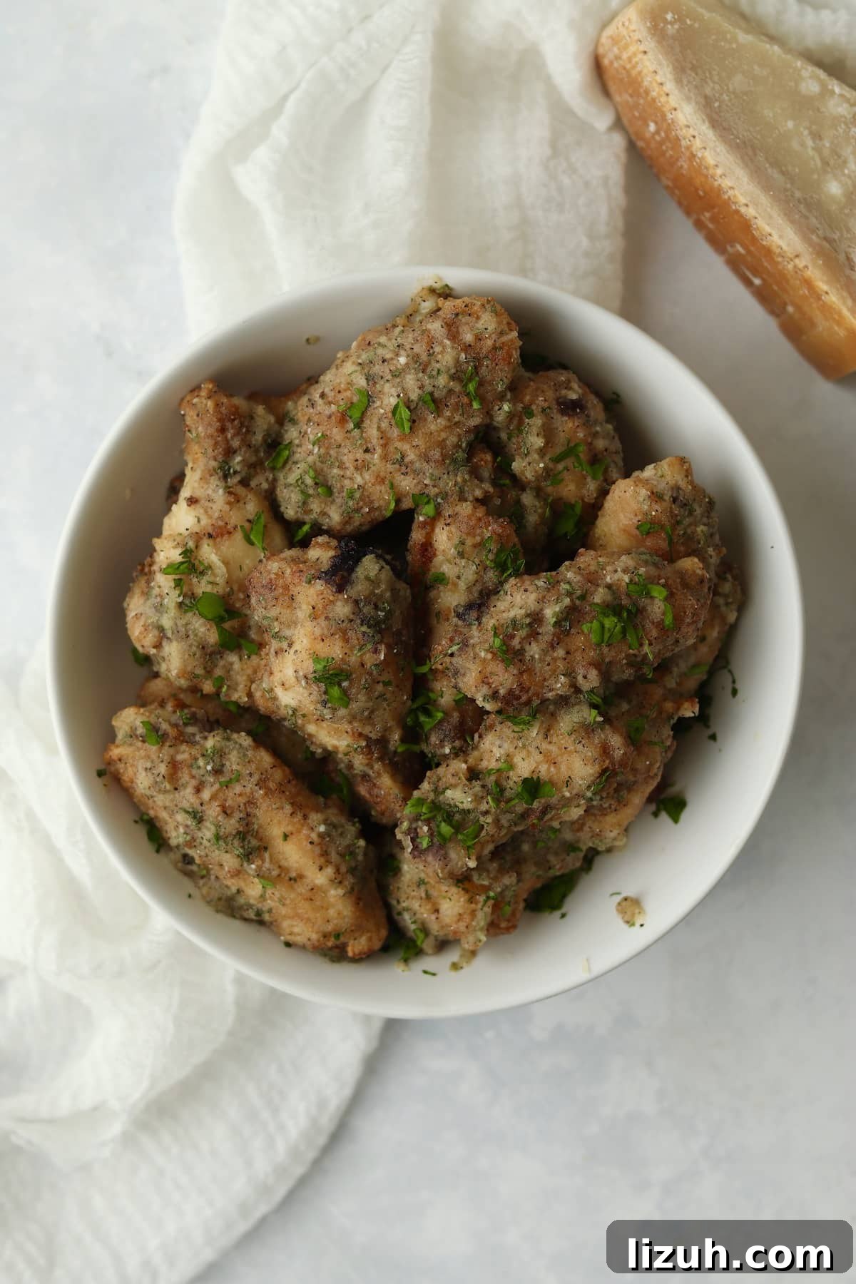 Crispy Garlic Parmesan Air Fryer Chicken Wings 8 Air Fryer Garlic Parmesan Chicken Wings in a bowl.