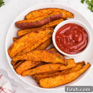 Overhead photo of sweet potato wedges made in the air fryer and served with a side of ketchup.