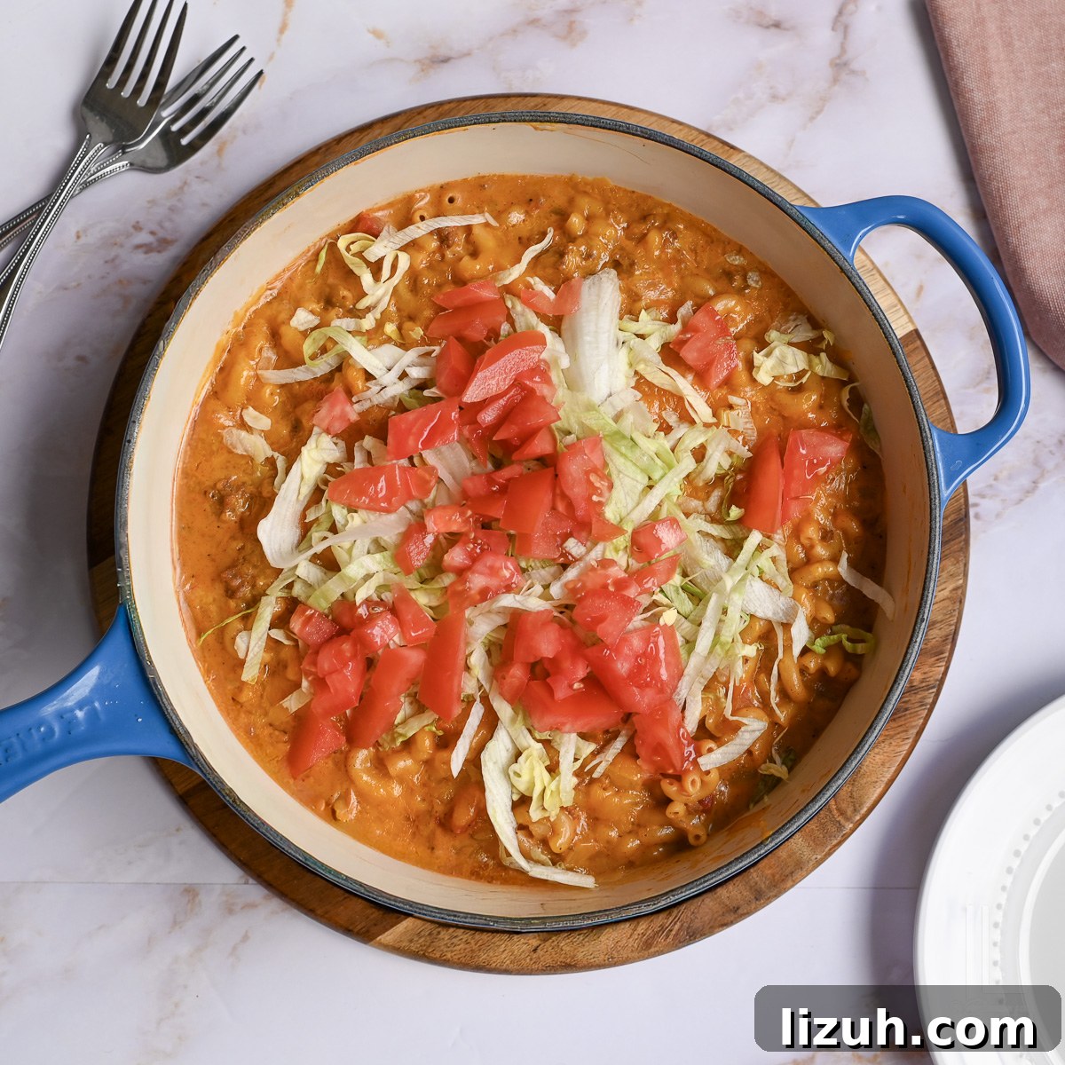 One-Pot Taco Mac and Cheese Recipe for Quick Weeknight Dinners 10 large skillet of taco mac and cheese, topped with chopped tomatoes and shredded lettuce.