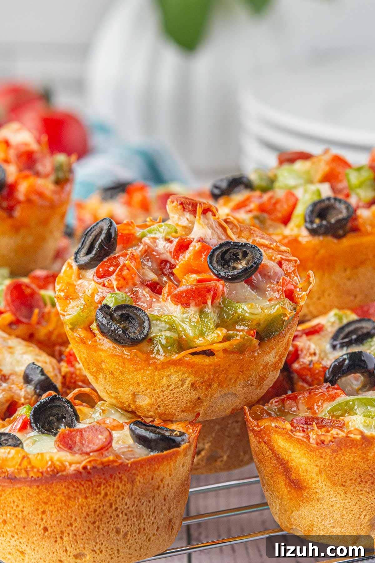 Mini Pizza Cups Recipe: Homemade Pizza Bites in 30 Minutes 2 An angled view of easy pizza cups stacked on top of each other.