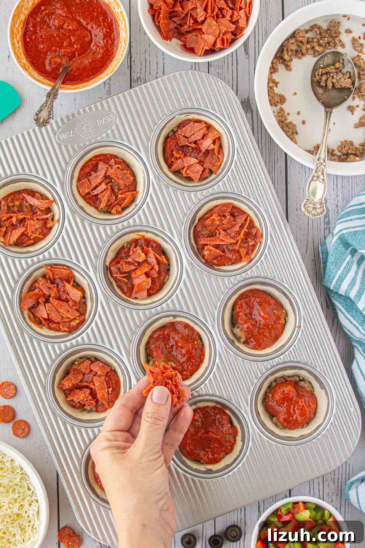 Mini Pizza Cups Recipe: Homemade Pizza Bites in 30 Minutes 6 Sprinkling pepperoni over the pizza cups.