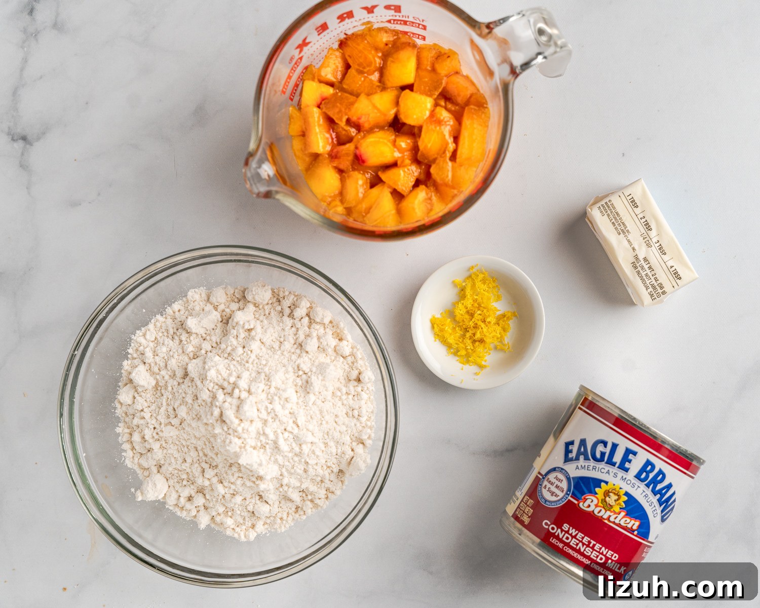 Ingredients. Diced peaches, biscuit mix, sweetened condensed milk, butter, and lemon zest.