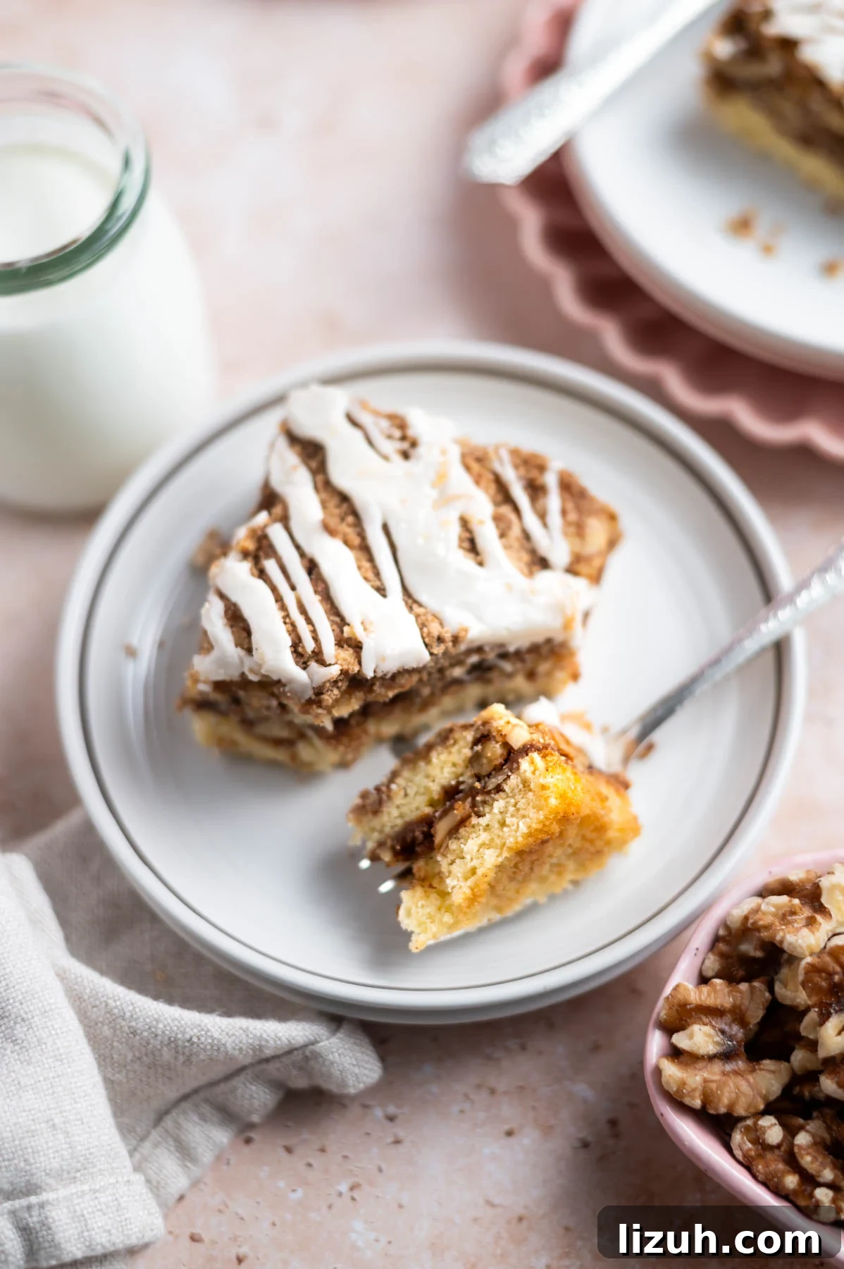 Cinnamon Walnut Coffee Cake Recipe for Weekend Baking 2 slice of cake on a plate with a fork holding a bite