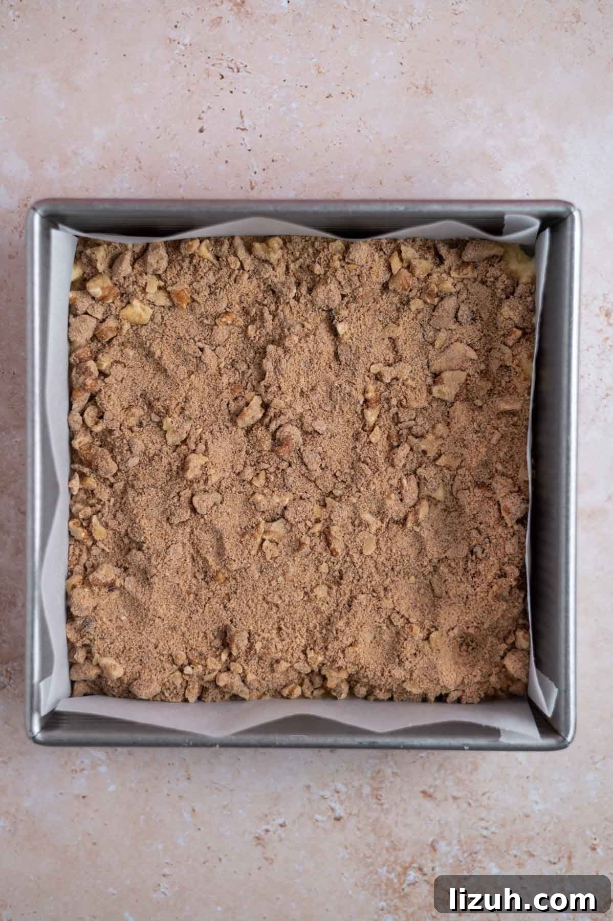 Cinnamon Walnut Coffee Cake Recipe for Weekend Baking 13 streusel layer over cake batter in a parchment lined baking pan