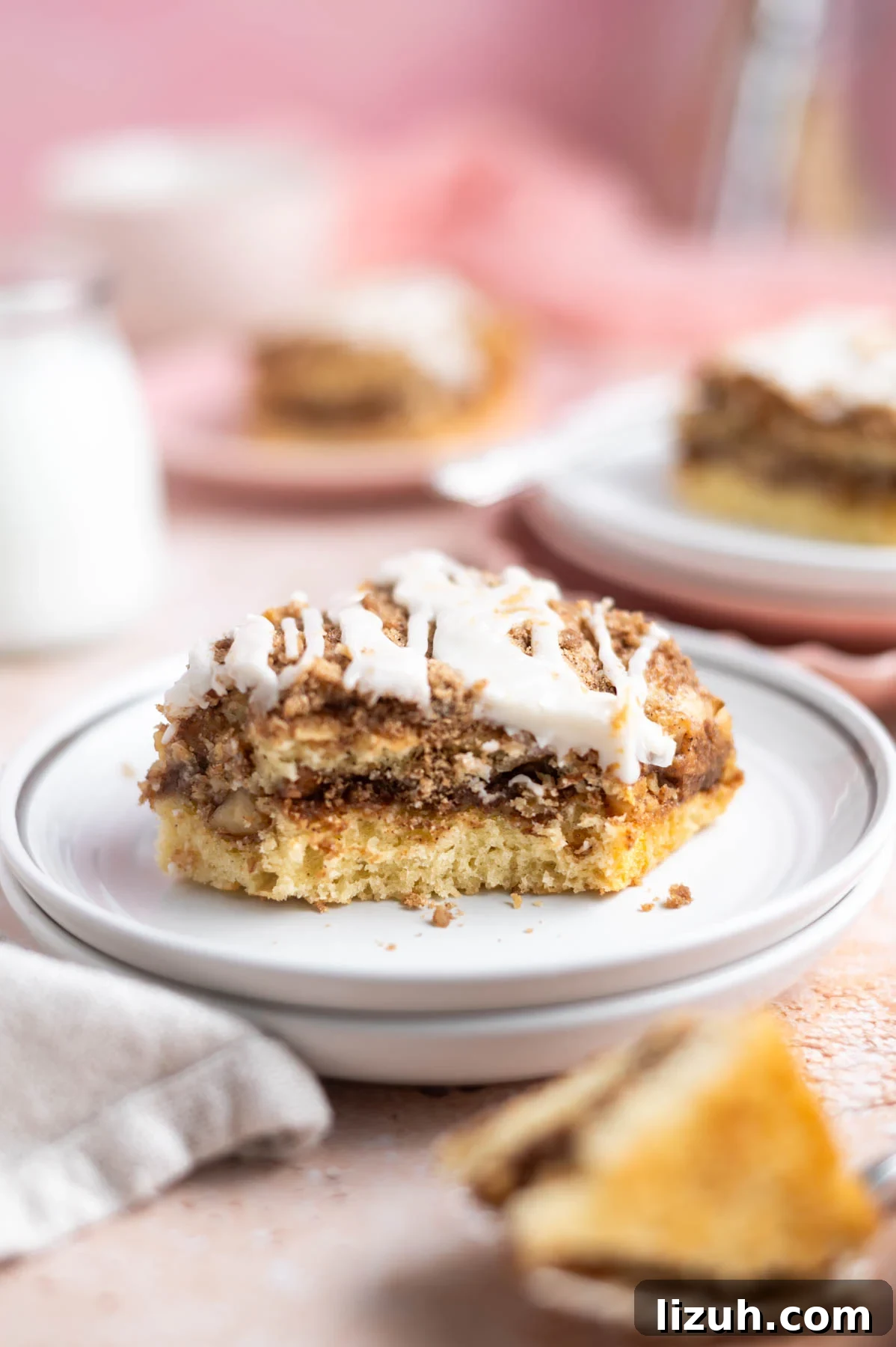 Cinnamon Walnut Coffee Cake Recipe for Weekend Baking 16 slice of cake on a plate with other slices in the background