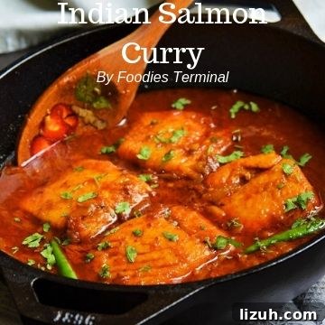 Kerala Coconut Fish Curry Recipe — Authentic Malabar Flavors 13 Indian Salmon curry in an iron wok with a wooden spatula