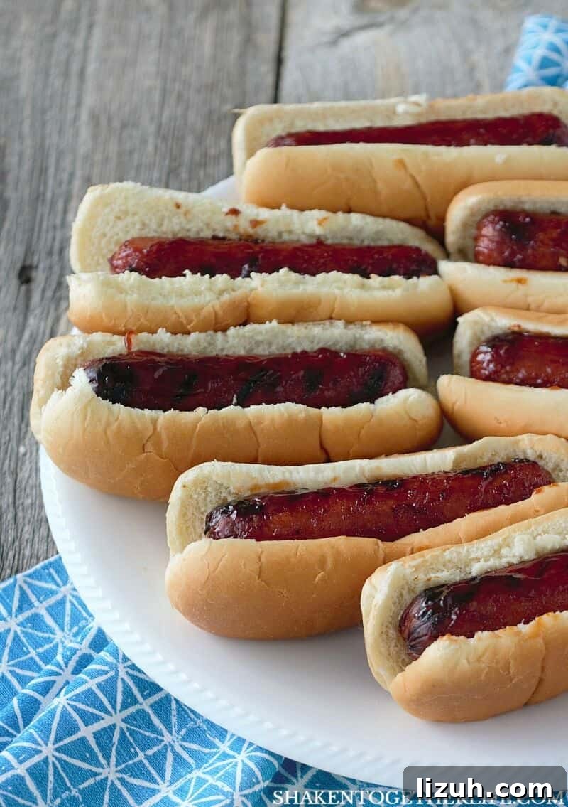 Grilled BBQ Glazed Smoked Sausage in buns on white plate