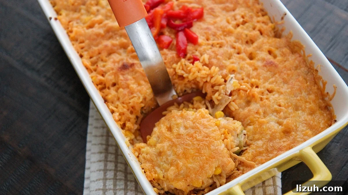 Imperial Rice: Creamy Baked Rice with Chicken and Shrimp 4 a casserole of imperial rice with an orange spatula lifting a portion out of the casserole.
