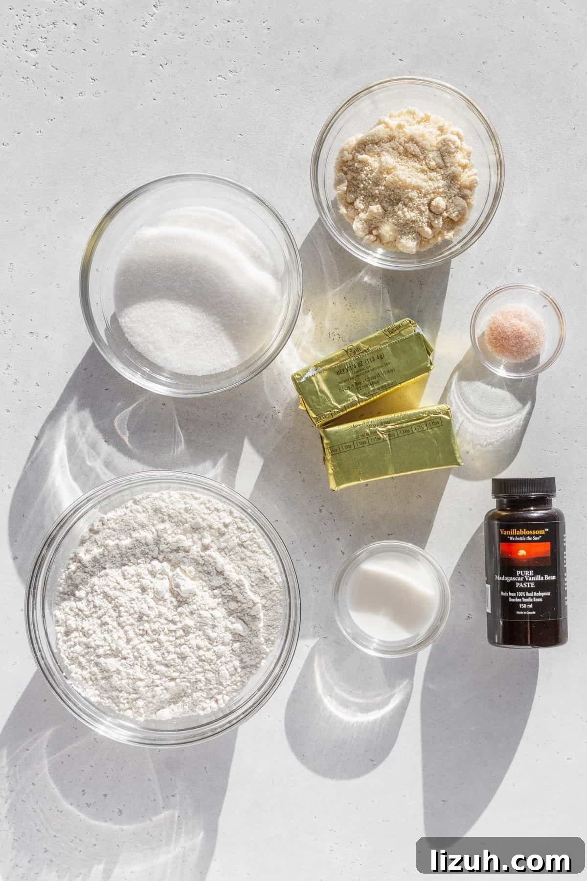Gluten-Free Sugar Cookie Recipe for Crisp, Chewy Cookies 3 Ingredients for gluten free sugar cookies measured out into bowls on a white surface.