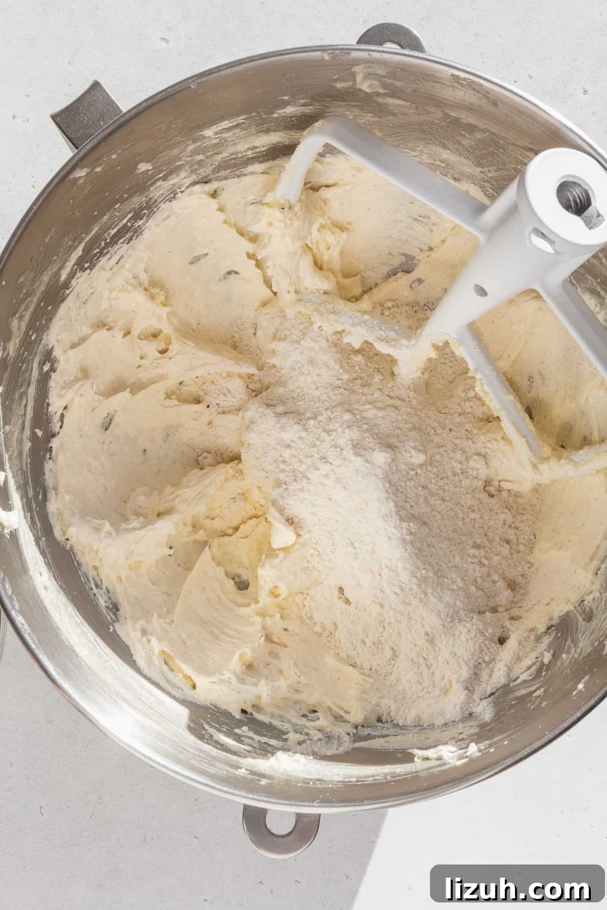 Gluten-Free Sugar Cookie Recipe for Crisp, Chewy Cookies 6 Dry ingredients added to the wet ingredients for sugar cookies in a metal bowl.