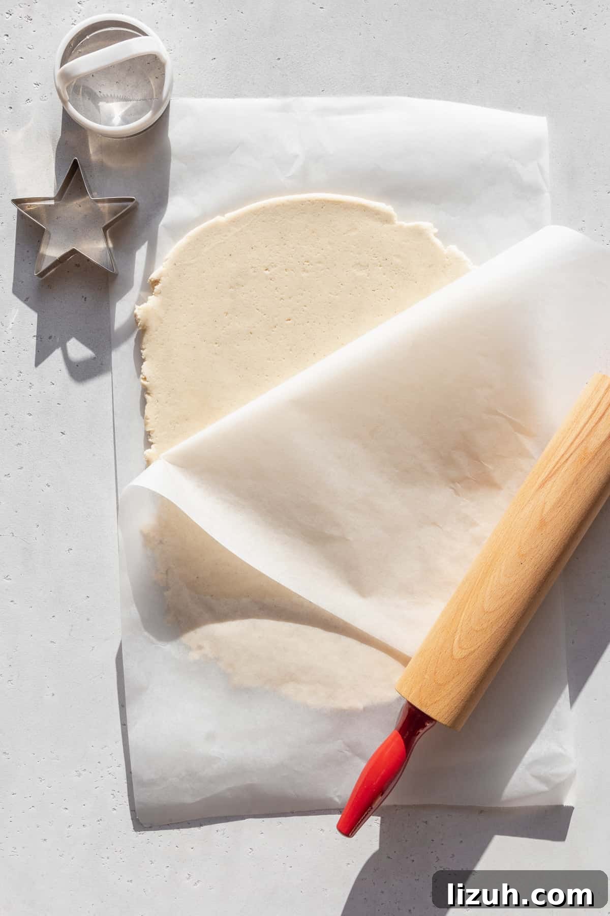 Gluten-Free Sugar Cookie Recipe for Crisp, Chewy Cookies 8 Gluten free sugar cookie dough rolled out between two sheets of parchment paper.