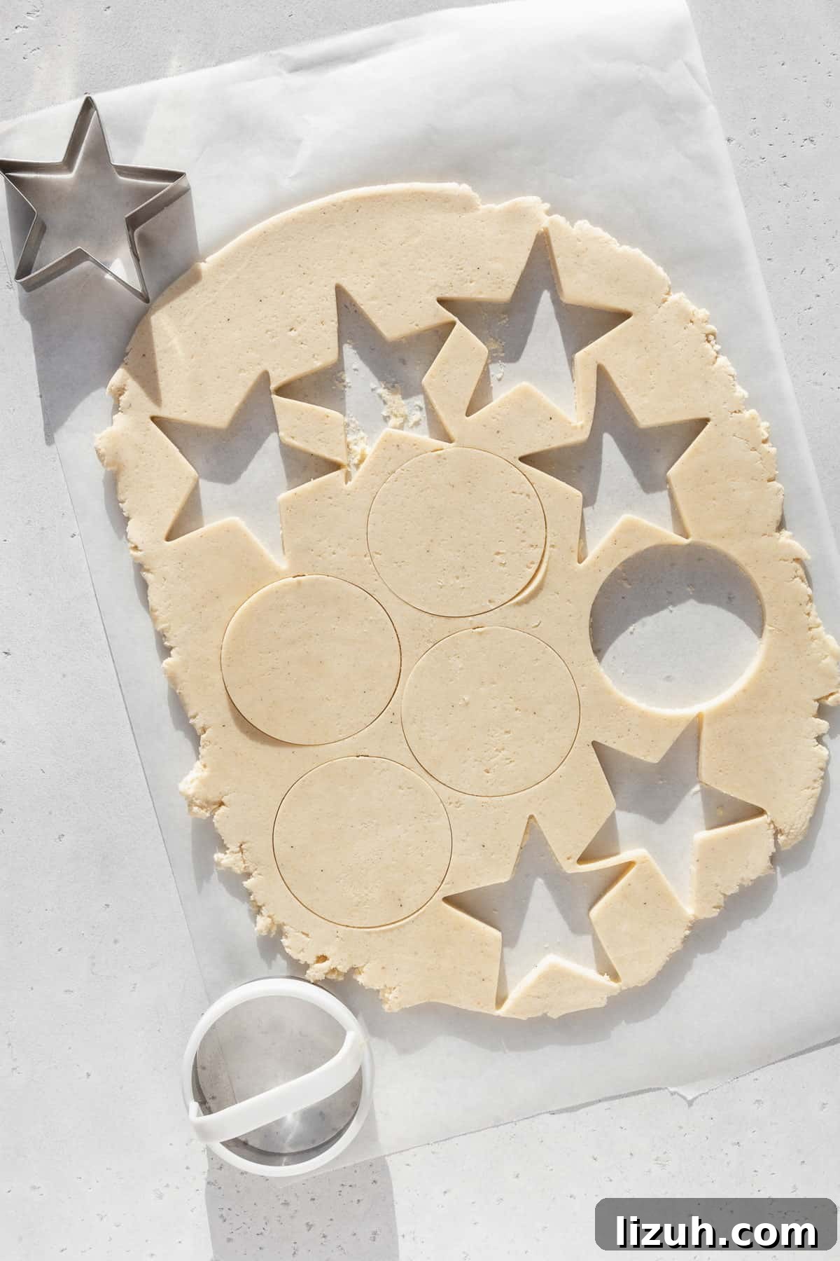 Gluten-Free Sugar Cookie Recipe for Crisp, Chewy Cookies 9 Shapes being cut out of rolled out sugar cookie dough.
