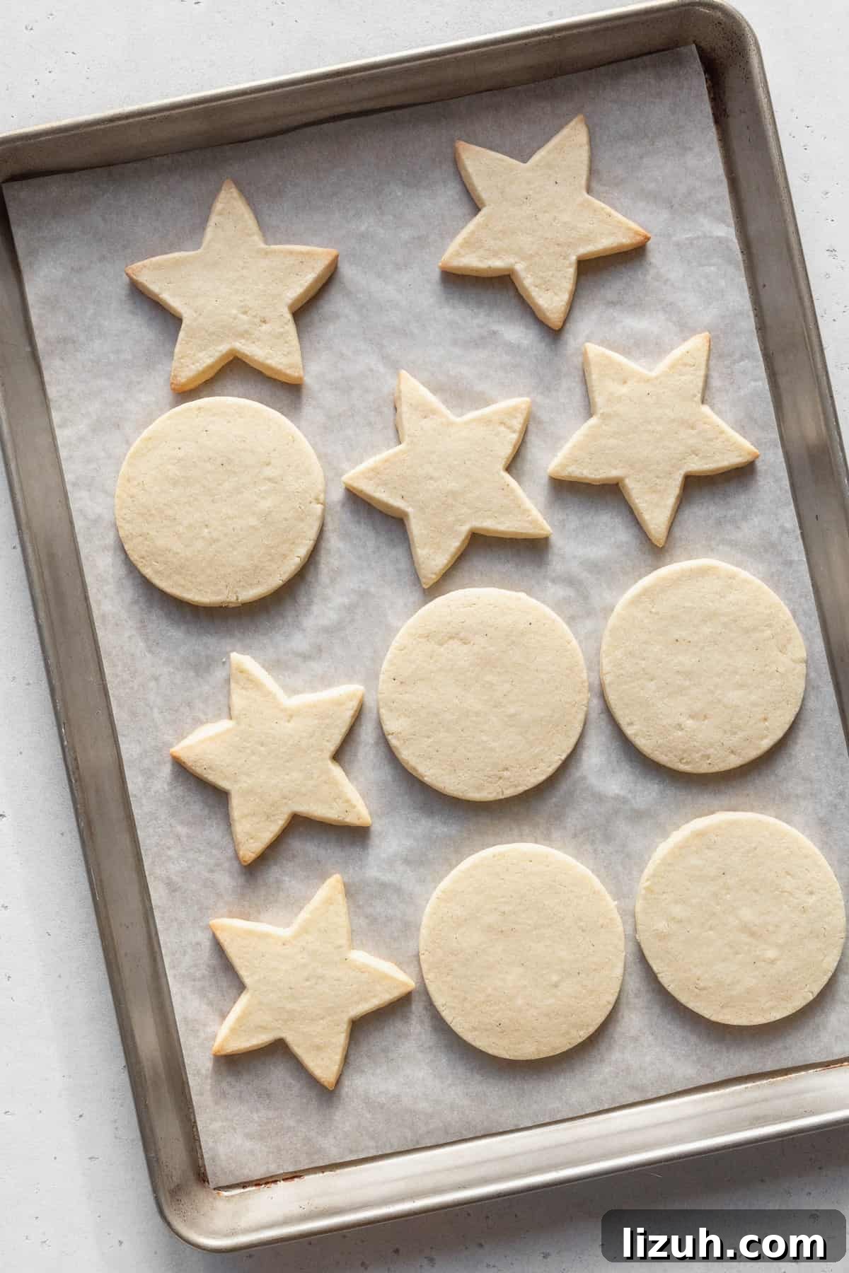 Gluten-Free Sugar Cookie Recipe for Crisp, Chewy Cookies 10 Baked gluten-free sugar cookies on a parchment paper lined baking sheet.