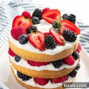 Decadent Mixed Berry Cake Recipe with Fresh Fruit Layers 10 Berry cake with mixed berries, whipped cream, and layered cake.
