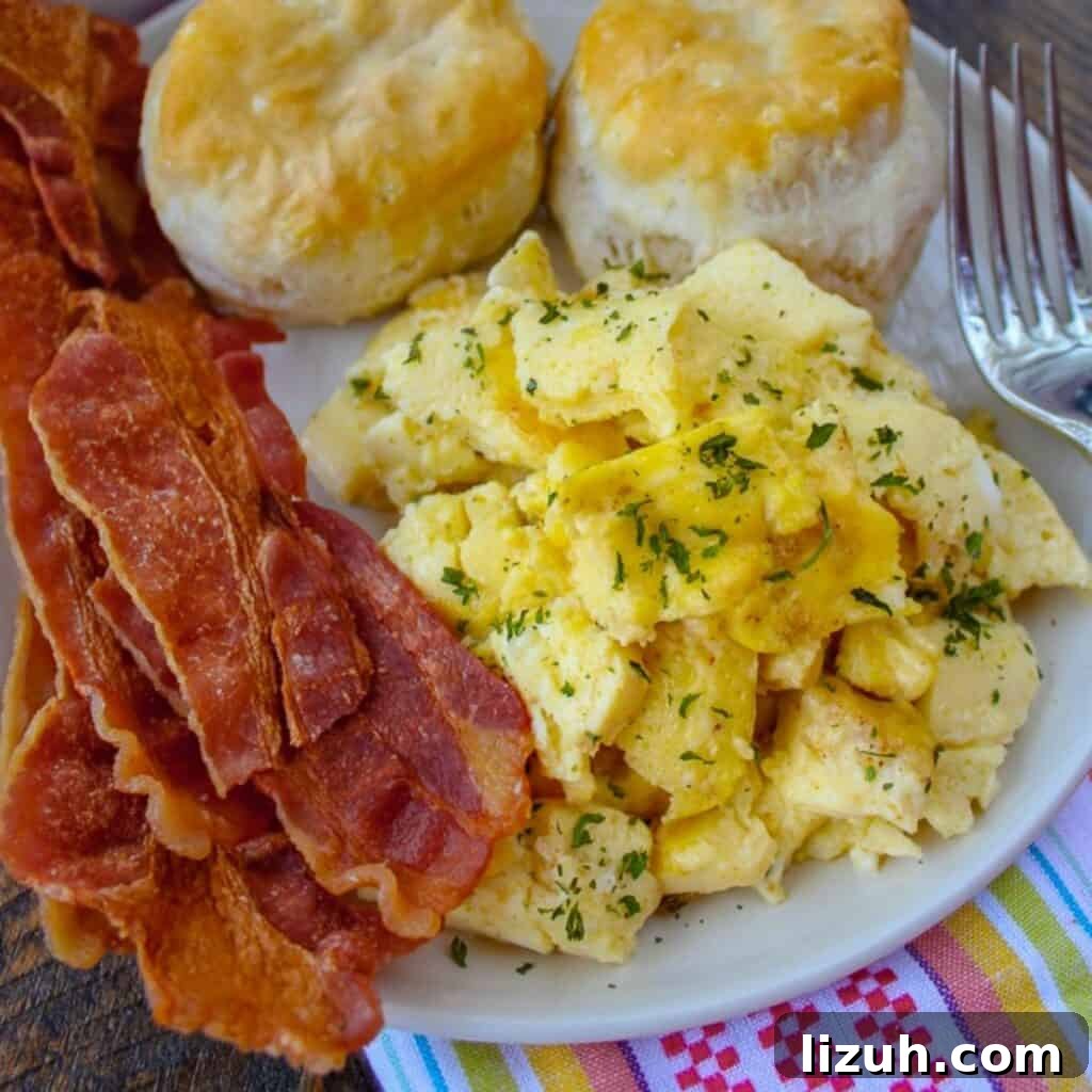 41 Perfect Side Dishes to Serve with Biscuits and Gravy 3 scrambled eggs, biscuits and bacon on a plate, perfect sides for sausage gravy.