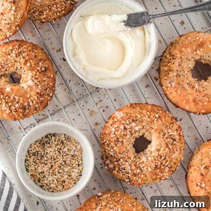 Two-Ingredient gluten free bagels on a cooling rack with cream cheese and everything bagel seasoning.