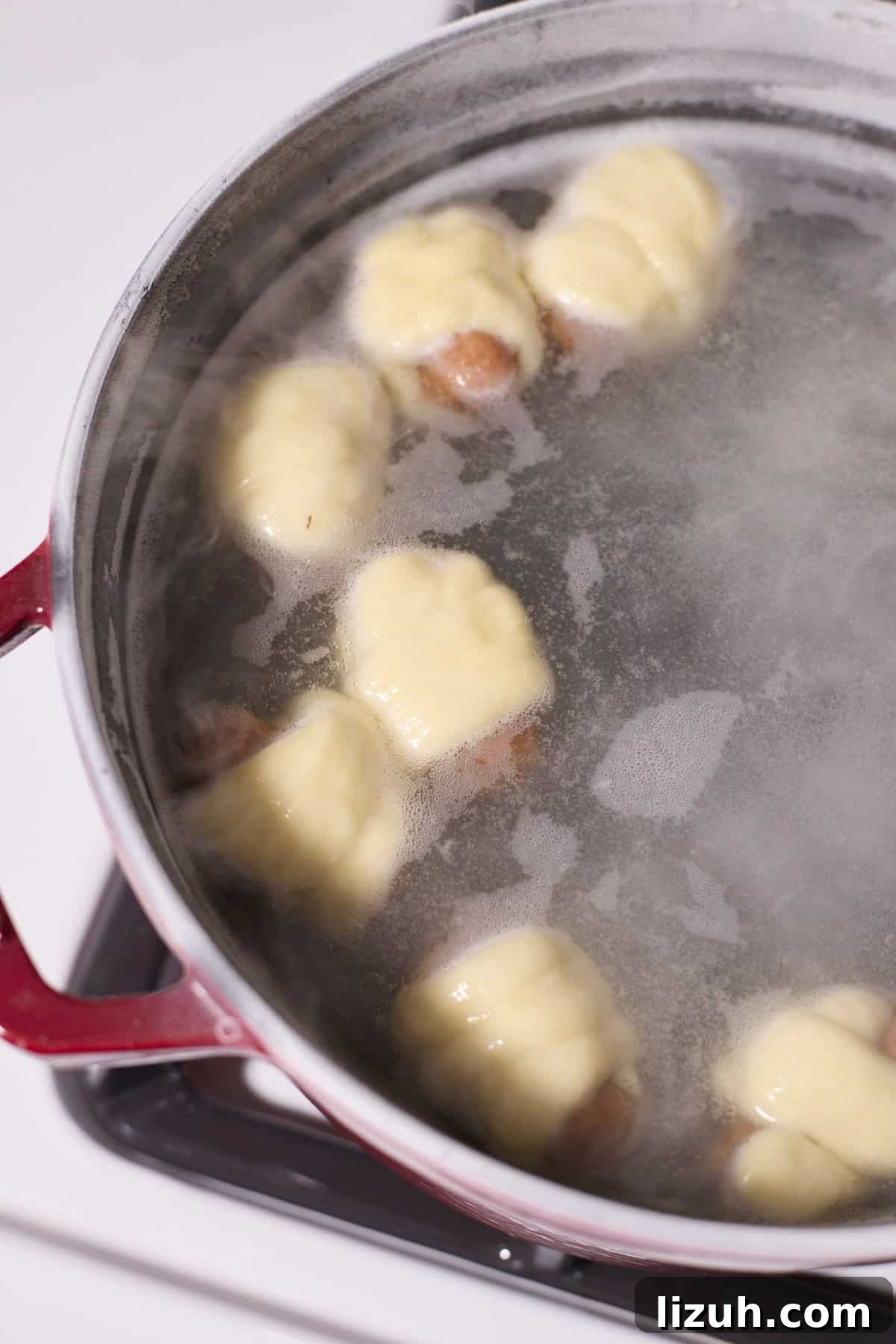 Sourdough Discard Pretzel Pigs in a Blanket Recipe 10 Pigs in a blanket floating in the boiling water.