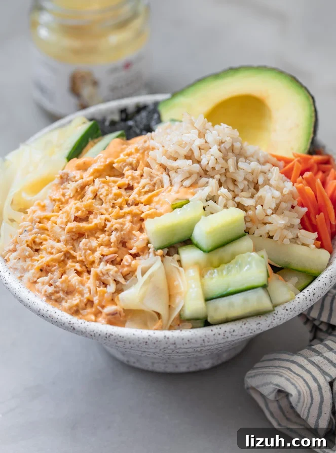 Spicy Tuna Poke Bowl Recipe — Quick Flavor-Packed Lunch 2 A tuna bowl with pickled cucmbers, carrots brown rice topped with spicy mayonnaise