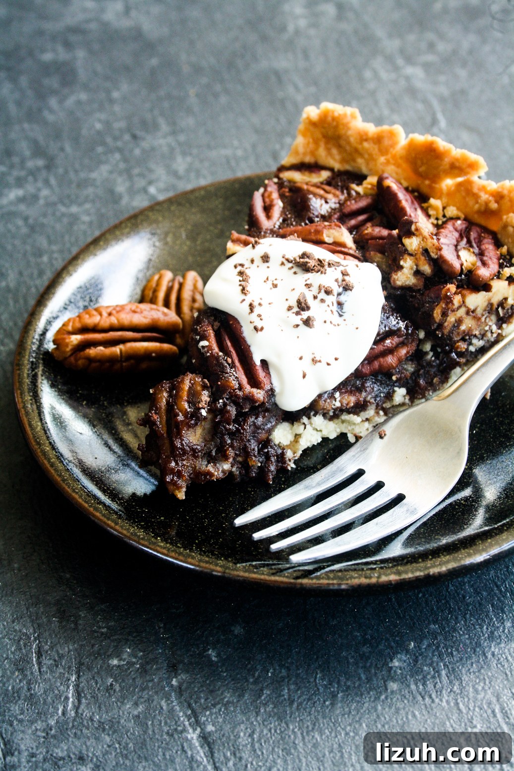 Rich and gooey dark chocolate pecan pie made with honey not corn syrup, on a homemade flaky pie crust