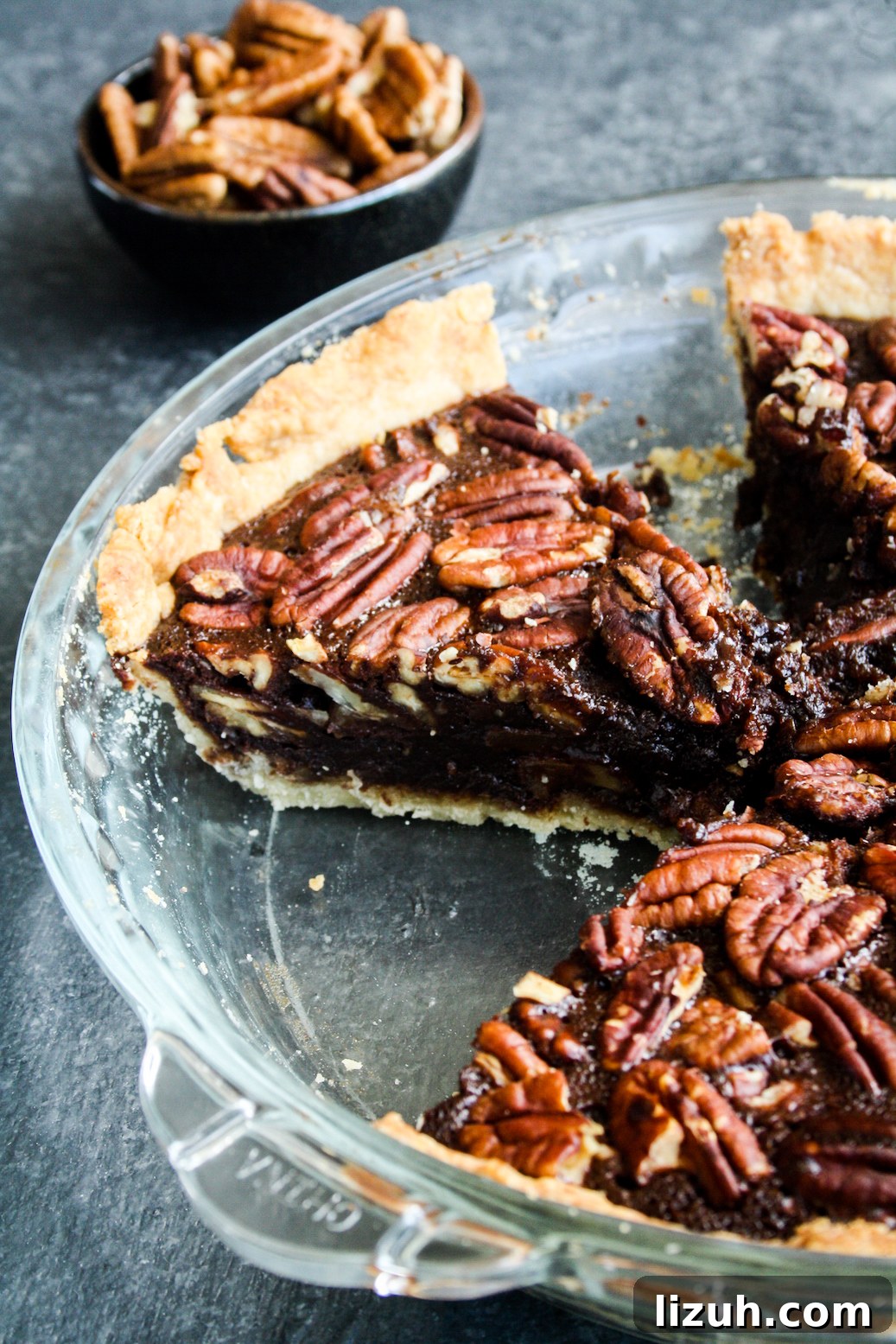 Rich and gooey dark chocolate pecan pie made with honey not corn syrup, on a homemade flaky pie crust