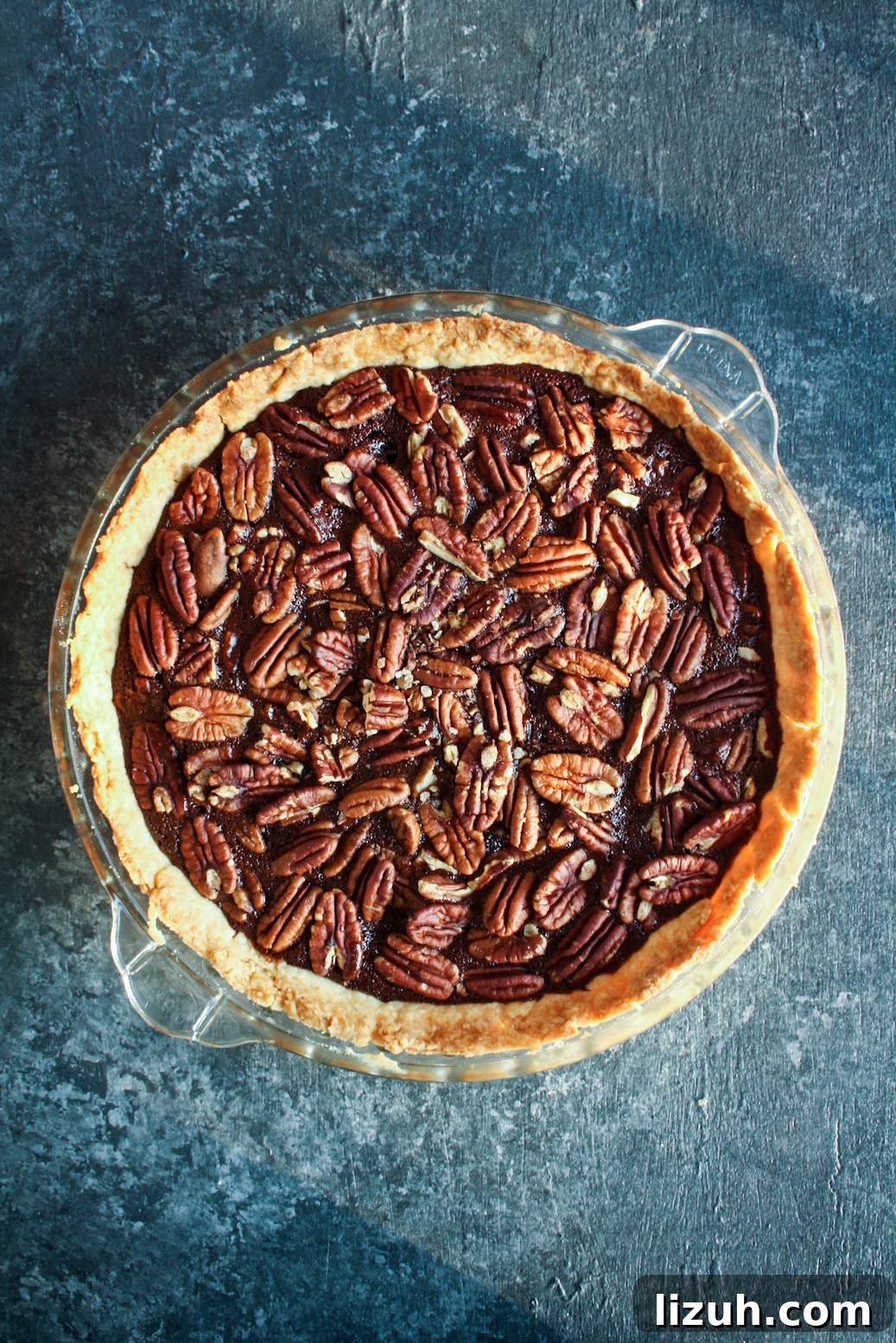 Rich and gooey dark chocolate pecan pie made with honey not corn syrup, on a homemade flaky pie crust