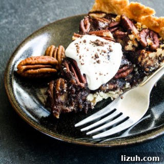 Rich and gooey dark chocolate pecan pie made with honey not corn syrup, on a homemade flaky pie crust