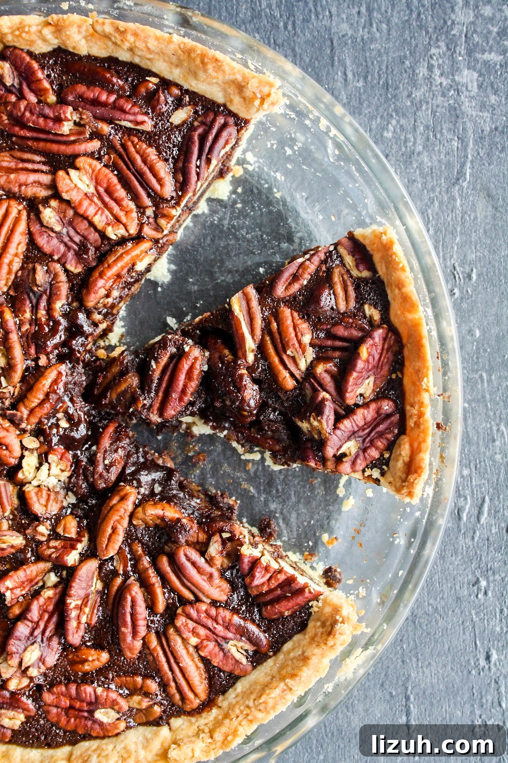 Rich and gooey dark chocolate pecan pie made with honey not corn syrup, on a homemade flaky pie crust