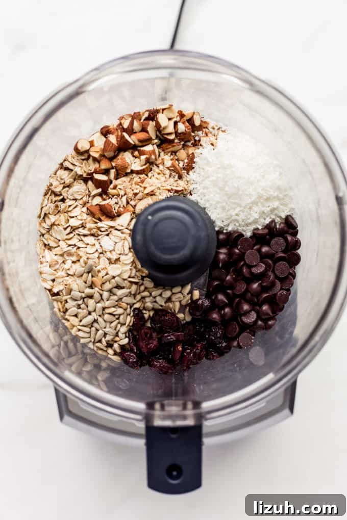 Trail Mix Energy Bites for Quick, Nutritious Snack Packs 4 a food processor with nuts, seeds, shredded coconut and chocolate chips in it