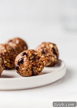 an energy ball on a white plate with a bite taken out of it