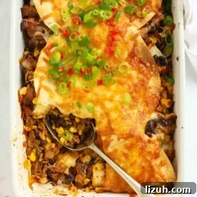 14-Day Meal Plan for Weight Loss and Balanced Nutrition 3 Looking down on a oven dish filled with Mexican beef with sweetcorn and beans, topped with tortillas and cheese, with a spoon dishing out.