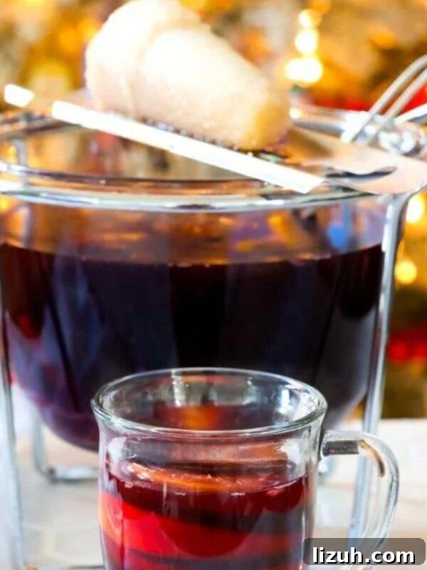 Eggnog Espresso Shooters: Holiday Coffee Cocktail Recipe 8 Feuerzangenbowle in a mug in front of a punch bowl with a sugar cone on fire over it
