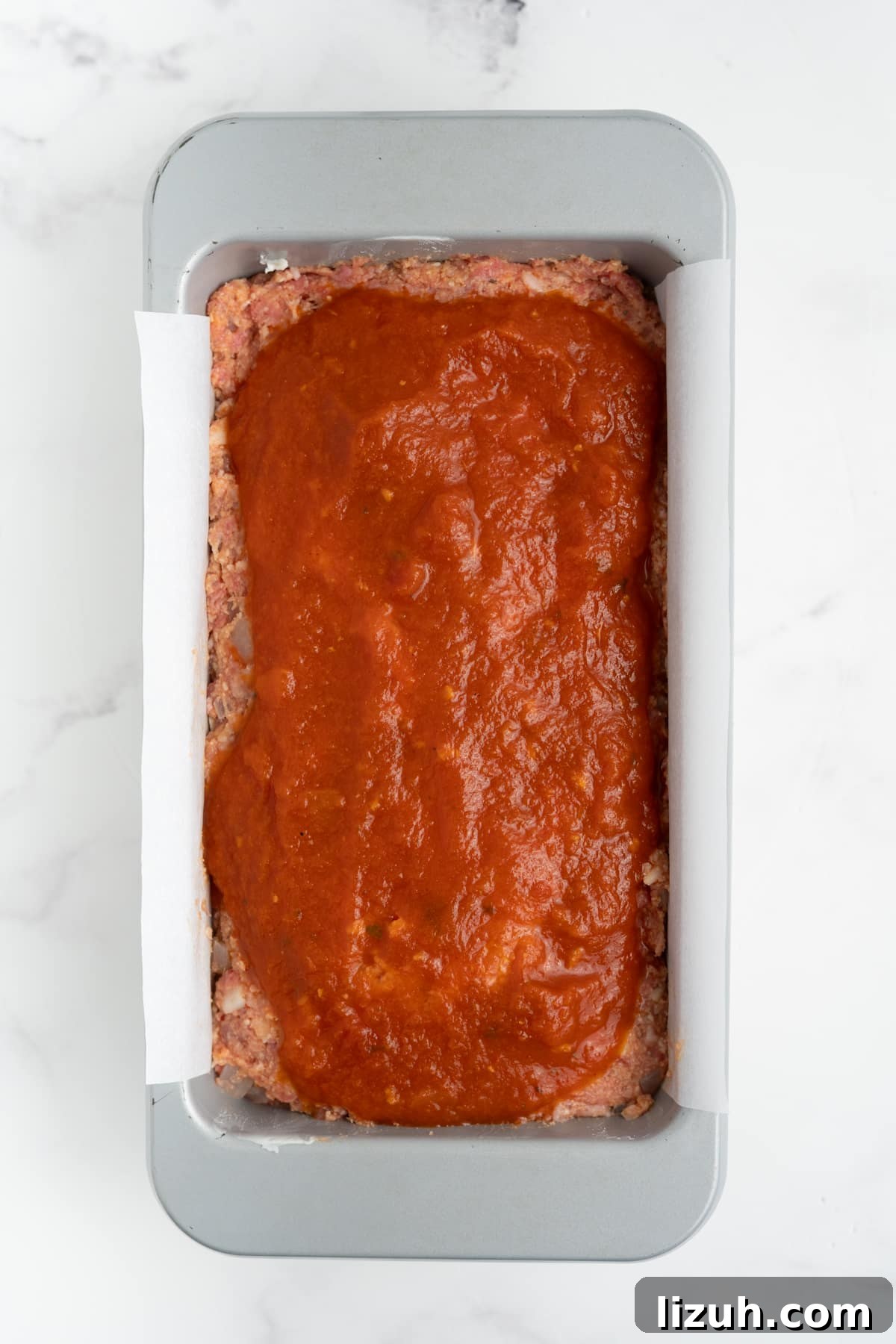 The marinara sauce poured over the meatloaf.