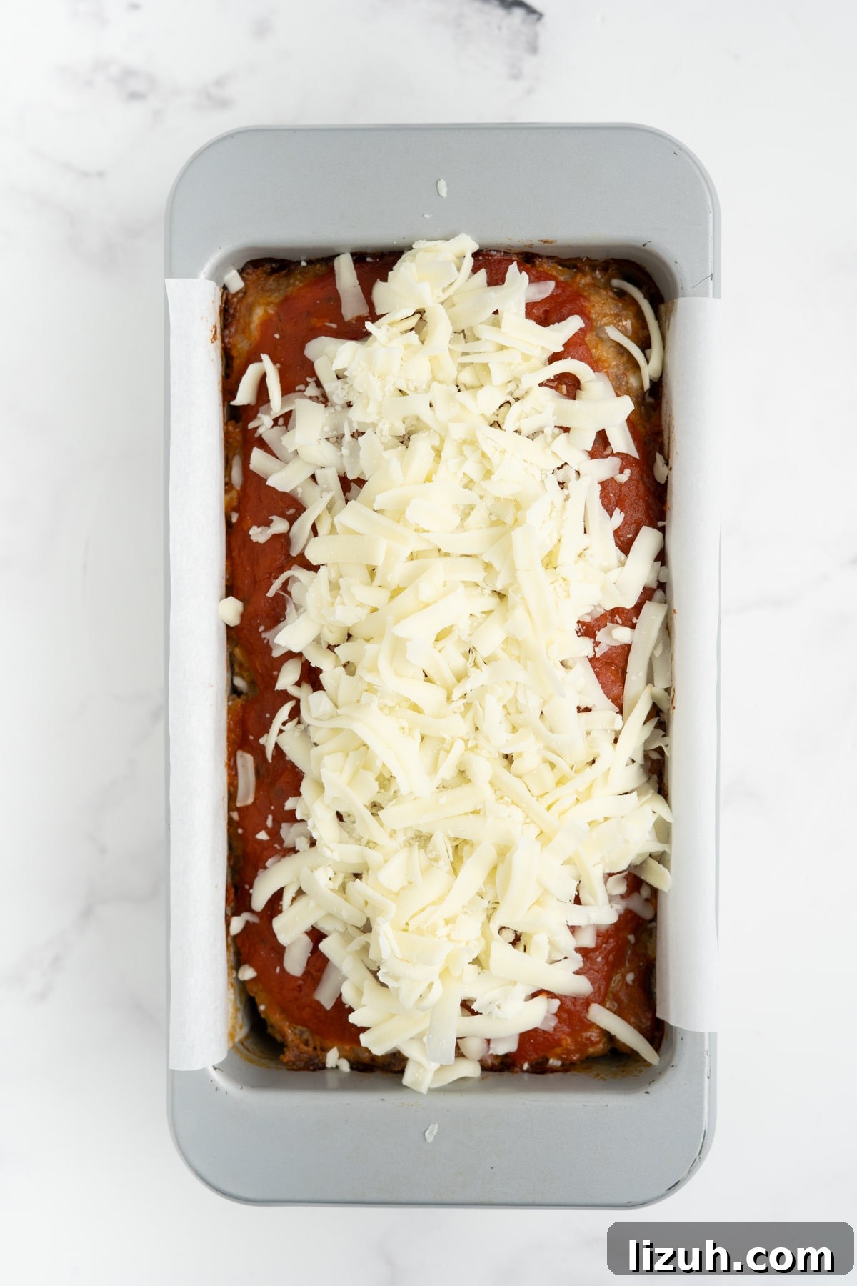 Cheese added on top of the Italian meatloaf.